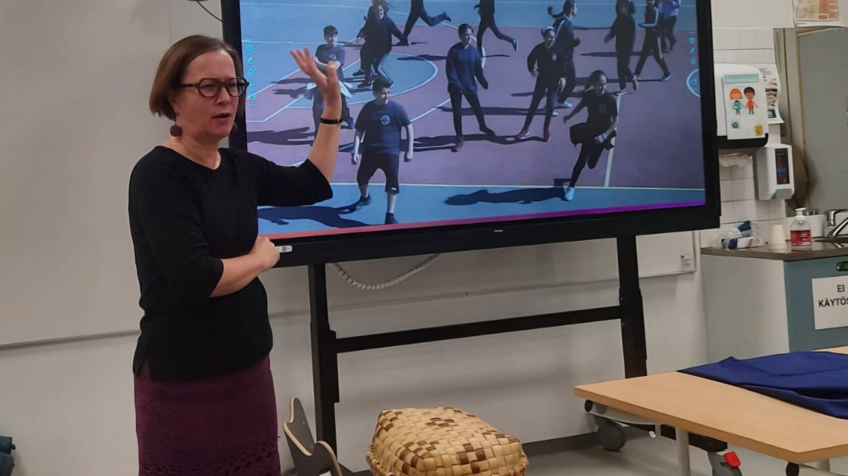 Iina-pappi näyttää kuvaa lapsista liikuntatunnilla Palestiinan Ramallahissa