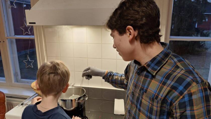 Pietari rakennuskerhossa kynttilöitä valamassa pienen kerholaisen kanssa