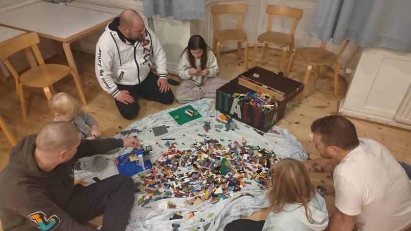 Isät ja lapset leikkimässä legoilla